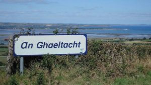 Sign for An Gaeltacht in a rural setting, publicisng Fórsa Gaeltacht grants.