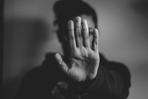 A woman holding up a hand, to represent victims of domestic abuse