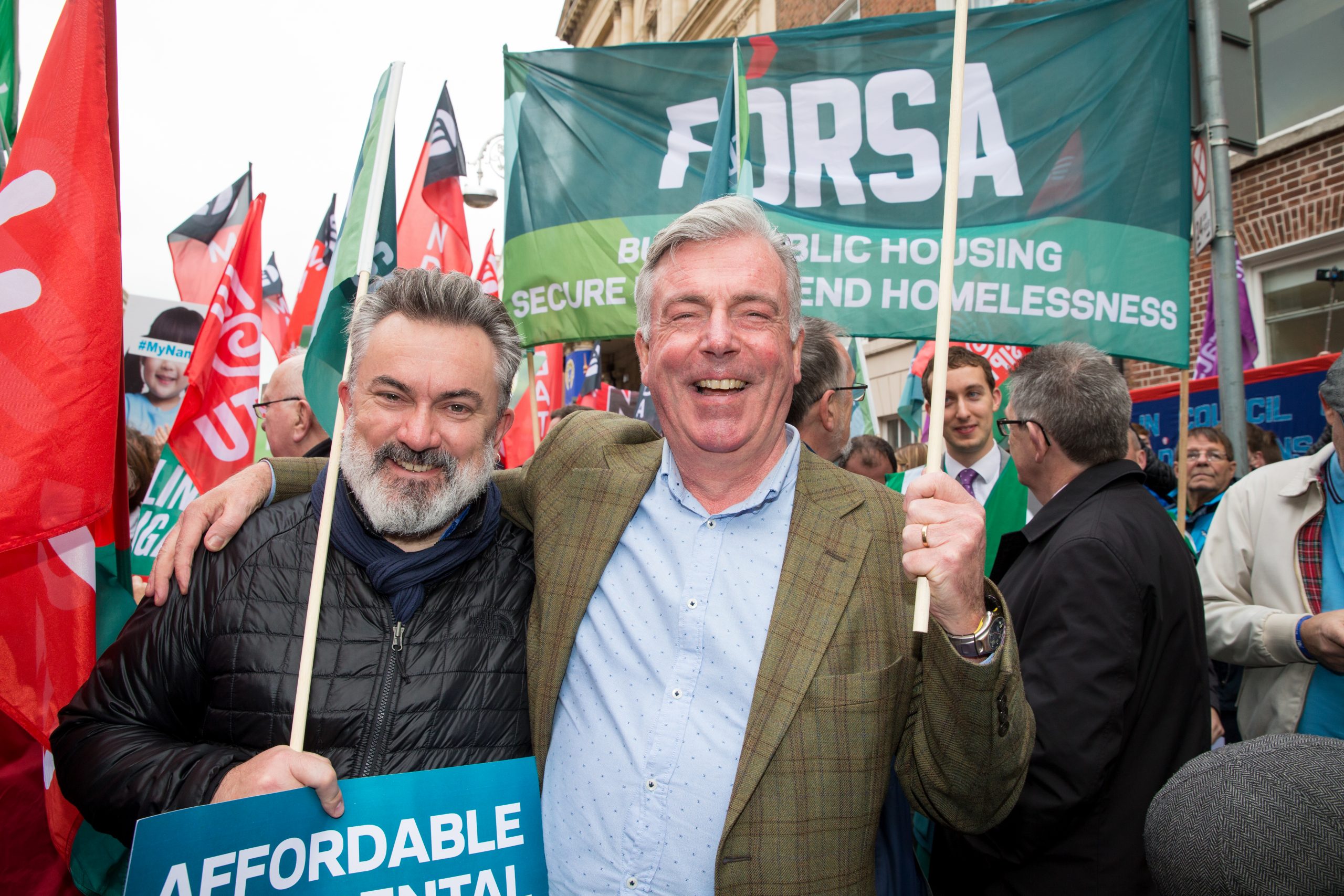 Two men at a workers protest, representing protect your pay