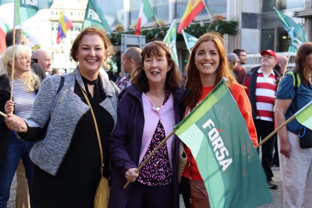 Three women at a worker's rally, representing the benefits of joining a trade union like Fórsa, such as solidarity and not having to deal with workplace issues alone.