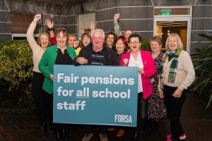 School secretaries and caretakers holding a large banner calling for pensions justice.