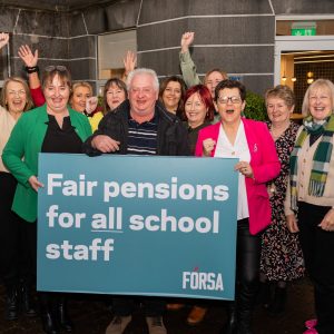 School secretaries and caretakers holding a large banner calling for pensions justice.