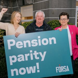3 forsa members holding up a banner hat says pension parity now and raising their hands in the air