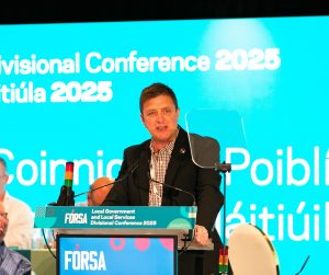Richy Carrothers speaking at podium at Local Governement and Local Services Divisional Conference 2025