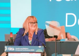 Ashley Connolly speaking at podium at Health and Welfare Divisional Conference 2025