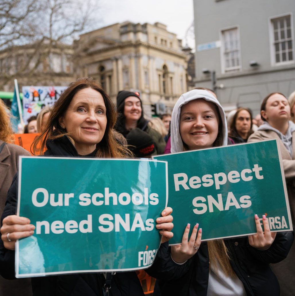 F&oacute;rsa SNA members holding up signs saying "our schools need SNAs" and "Respect SNAs" outside Leinster House, for a protest against SNA Cuts.
